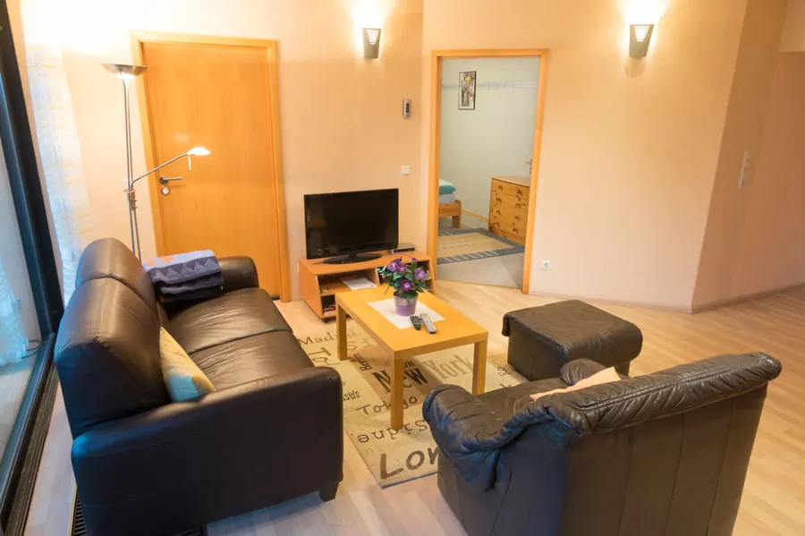 Wohnzimmer mit Ledersofa und TV – Monteurwohnung Bergisch Gladbach