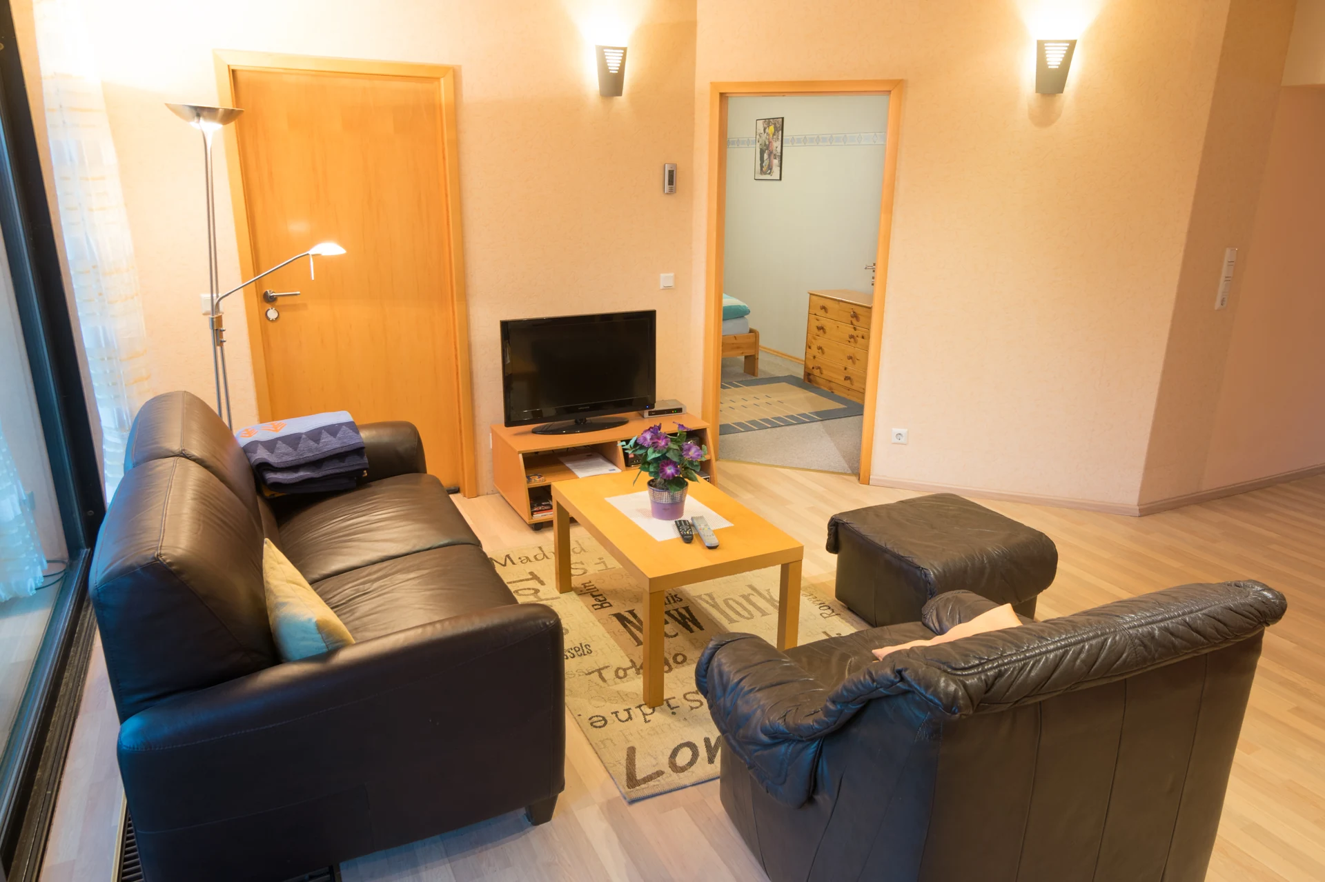 Geräumiges Wohnzimmer mit Ledersofa und TV – Monteurwohnung Bergisch Gladbach